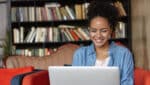 Woman smiling while using laptop.